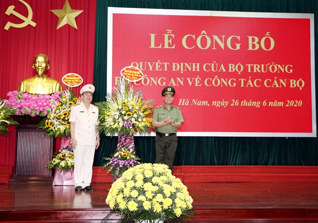 Thứ trưởng Bộ Công an Lê Tấn Tới tặng hoa chúc mừng Đại tá Nguyễn Văn Trung. Ảnh: TG